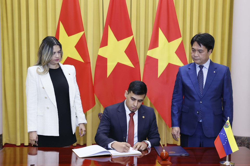Đại sứ Venezuela Juan Carlos Fernandes Juarez viết lưu bút. (Ảnh: Thống Nhất/TTXVN)