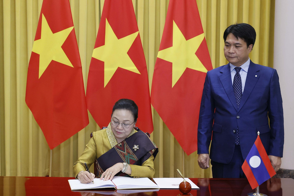 Đại sứ Cộng hòa Dân chủ Nhân dân Lào Khamphao Ernthavanh viết lưu bút. (Ảnh: Thống Nhất/TTXVN)