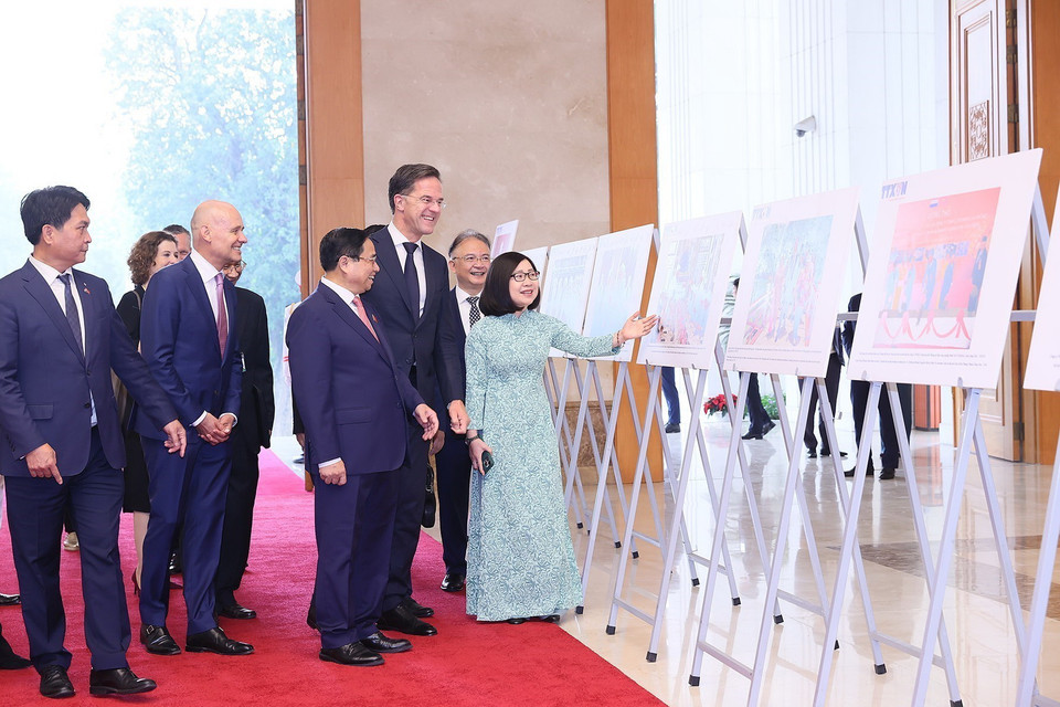 Phó Tổng Giám đốc TTXVN Đoàn Thị Tuyết Nhung giới thiệu những bức ảnh tiêu biểu về quan hệ Việt Nam-Hà Lan với hai Thủ tướng. (Ảnh: Dương Giang/TTXVN)