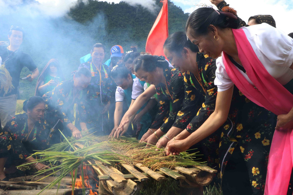 Sau khi cúng xong, lúa sẽ được nướng trên lửa để làm cốm. (Ảnh: Nguyễn Oanh/TTXVN)