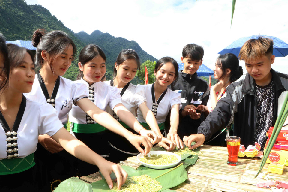 Người dân và du khách thưởng thức cốm tại lễ hội. (Ảnh: Nguyễn Oanh/TTXVN)