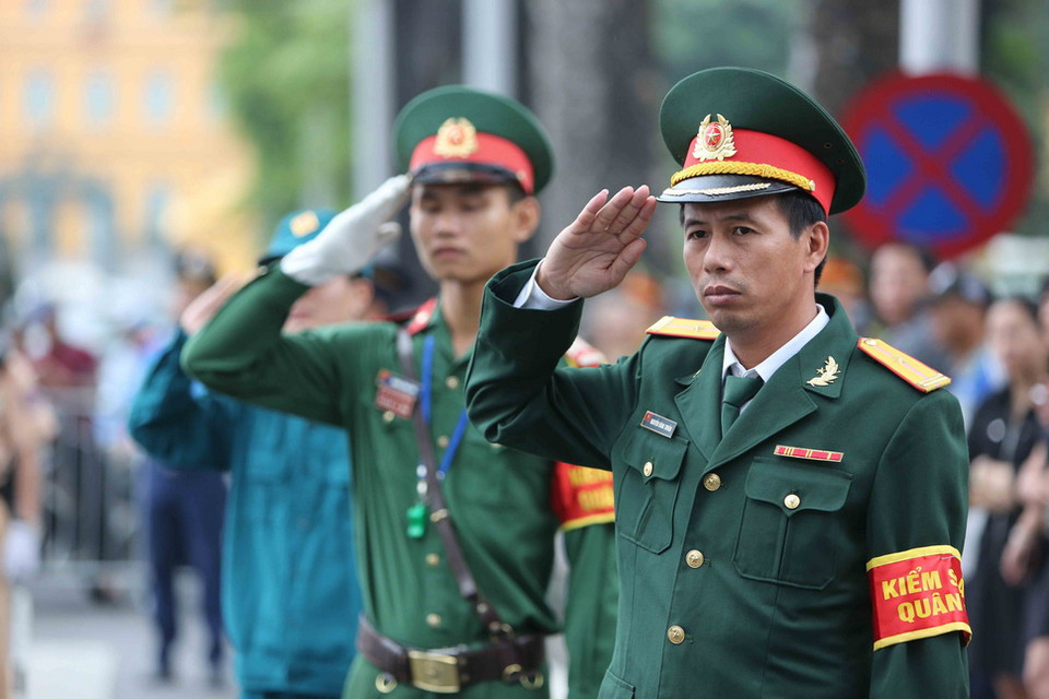 Cán bộ, chiến sỹ lực lượng vũ trang thực hiện nghi thức khi xe đưa linh cữu Chủ tịch nước Trần Đại Quang đi qua. (Ảnh: TTXVN)