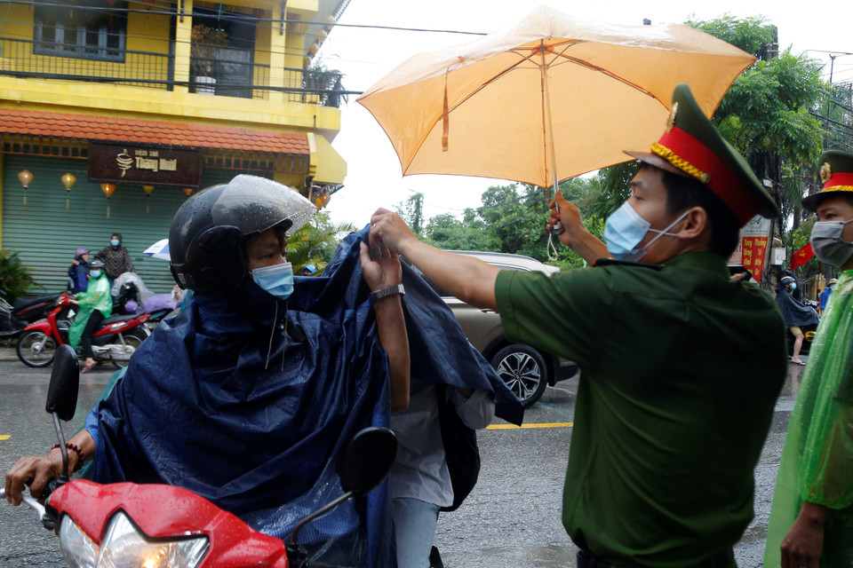 Lực lượng công an và tình nguyện viên phải vất vả làm việc liên tục để đón các em đến điểm thi một cách thuận lợi nhất. (Ảnh: Hiển Nguyễn/Vietnam+) 