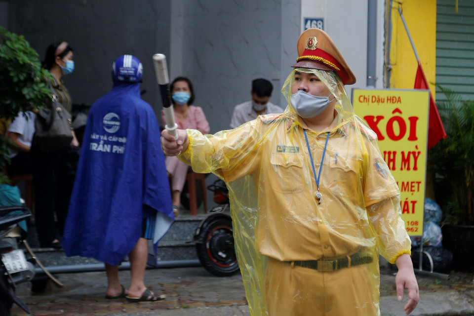 Lực lượng cảnh sát giao thông làm việc hết công suất để duy trì giao thông nơi ngoài điểm thi do có quá nhiều ô tô đưa thí sinh bị ùn ứ. (Ảnh: Hiển Nguyễn/Vietnam+) 