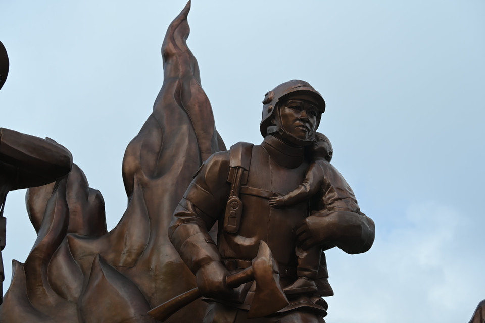 Cận cảnh hình tượng người lính phòng cháy chữa cháy bế em nhỏ. (Ảnh: PV/Vietnam+)