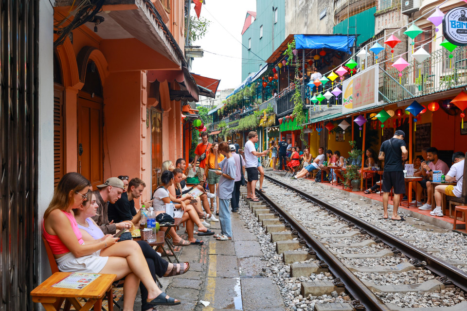 Nhiều khách du lịch tự mách nhau đến Hà Nội nhất định phải ghé qua đây. Họ ngồi nhâm nhi ly càphê hay lai rai vài chai bia và trông ngóng từng chuyến tàu chạy qua. (Ảnh: Minh Sơn/Vietnam+)