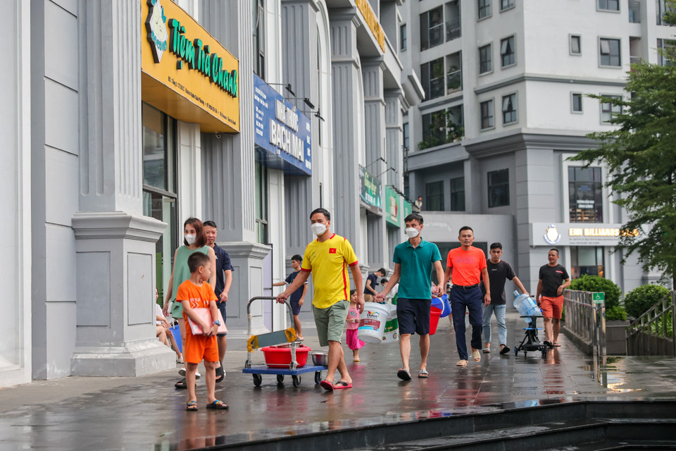 Hàng trăm cư dân sống tại đây phải mang can, xô, thùng... thậm chí là chậu xuống sảnh tòa nhà để lấy nước sạch. (Ảnh: Minh Sơn/Vietnam+)