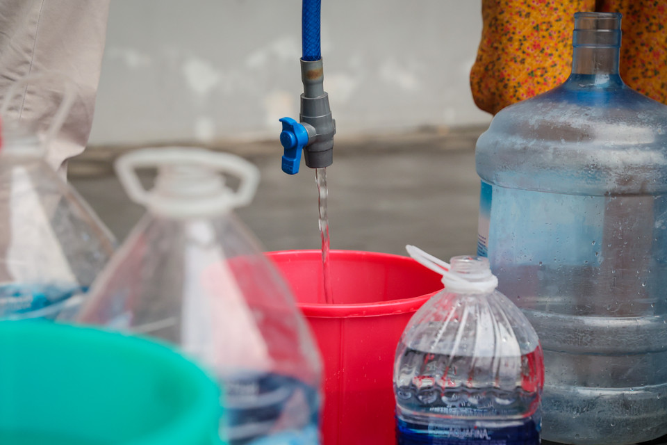 Lượng nước từ bể trữ nước chung cư chảy ra nhỏ giọt khiến nhiều người phải chờ đợi rất lâu để có thể lấy được nước sạch. (Ảnh: Minh Sơn/Vietnam+)