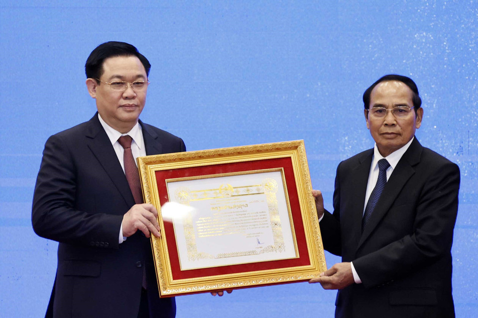 Ông Bounthong Chitmany - Ủy viên Bộ Chính trị, Thường trực Ban Bí thư Trung ương Đảng Nhân dân cách mạng Lào, Phó Chủ tịch nước Cộng hòa dân chủ Nhân dân Lào trao Huân chương Vàng Quốc gia cho ông Vương Đình Huệ - Uỷ viên Bộ Chính trị, Chủ tịch Quốc hội. (Ảnh: Thống Nhất/TTXVN)