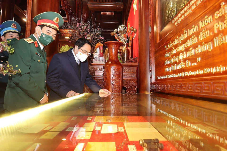 Thủ tướng Phạm Minh Chính xem ảnh và kỷ vật về Chủ tịch Hồ Chí Minh với lực lượng Phòng không-Không quân. (Ảnh: Dương Giang/TTXVN)