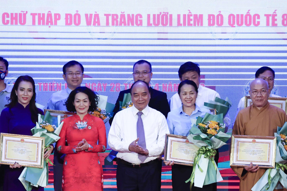 Chủ tịch nước Nguyễn Xuân Phúc tặng hoa cho các nhà tài trợ. (Ảnh: Thống Nhất/TTXVN)