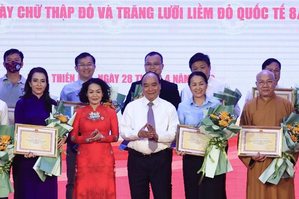 Chủ tịch nước Nguyễn Xuân Phúc tặng hoa, tri ân các nhà tài trợ. (Ảnh: Thống Nhất/TTXVN)