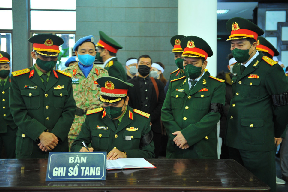 Lãnh đạo Bộ Quốc phòng viết cảm tưởng vào sổ tang tại Lễ viếng liệt sỹ, Trung tá Đỗ Anh. (Ảnh: Minh Đức/TTXVN)