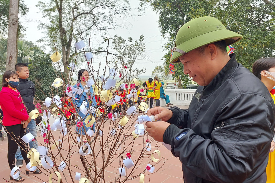 Người dân dự hội có thể hái câu đối rồi nhờ các cụ cao niên giảng giải để xem vận may trong năm. (Ảnh: Minh Thu/Vietnam+)