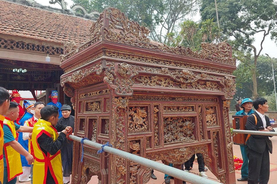  Lễ rước kiệu được tiến hành từ 12h30 ngày 12 tháng Giêng. Trên kiệu là các sắc phong, bài vị, quả Phết được cất giữ trong cung cấm của đình làng từ ngày mùng 10/10 Âm lịch. Kiệu được khiêng từ đình ra đền do các binh sỹ hộ tống. (Ảnh: Minh Thu/Vietnam+)