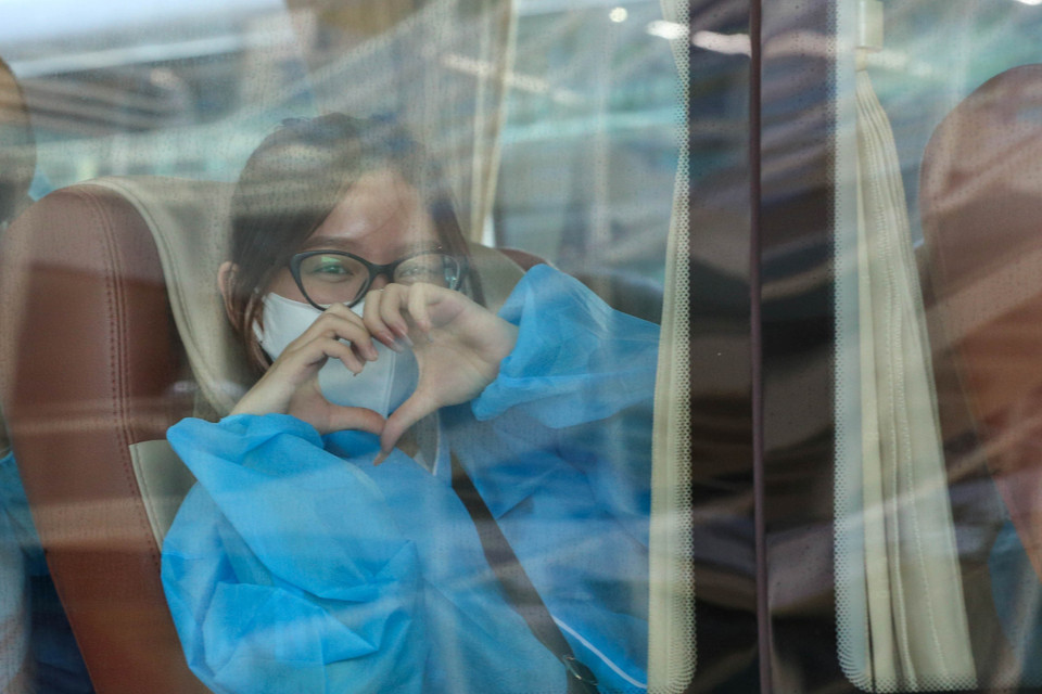 Niềm vui của một cô gái sau khi về tới sân bay Đà Nẵng và lên xe thực hiện cách ly theo quy định. (Ảnh: Trần Lê Lâm/TTXVN)