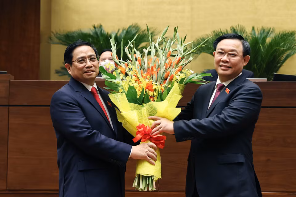 Chủ tịch Quốc hội Vương Đình Huệ tặng hoa chúc mừng Thủ tướng Phạm Minh Chính. (Ảnh: Dương Giang/TTXVN)