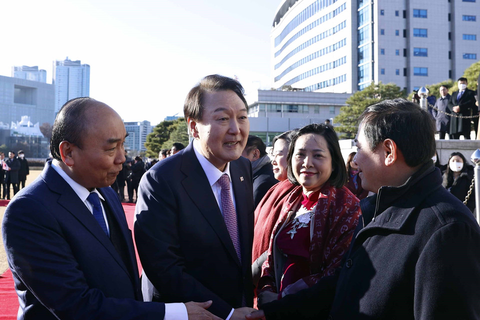 Chủ tịch nước Nguyễn Xuân Phúc giới thiệu các thành viên Đoàn đại biểu cấp cao Việt Nam với Tổng thống Hàn Quốc Yoon Suk-yeol. (Ảnh: Thống Nhất/TTXVN)