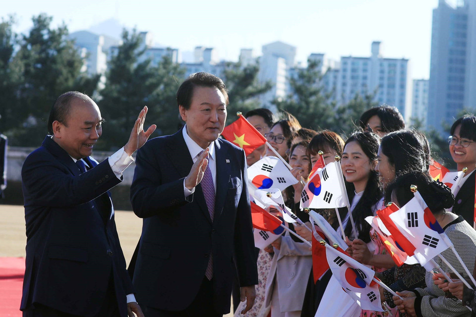 Chủ tịch nước Nguyễn Xuân Phúc và Tổng thống Yoon Suk-yeol được chào mừng tại lễ đón. (Ảnh: Thống Nhất/TTXVN)