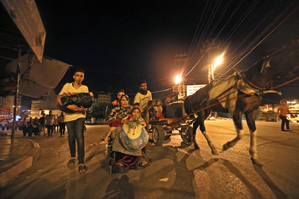 Người Palestine sơ tán khỏi nhà sau cuộc pháo kích lớn của quân đội Israel. (Ảnh: AFP)