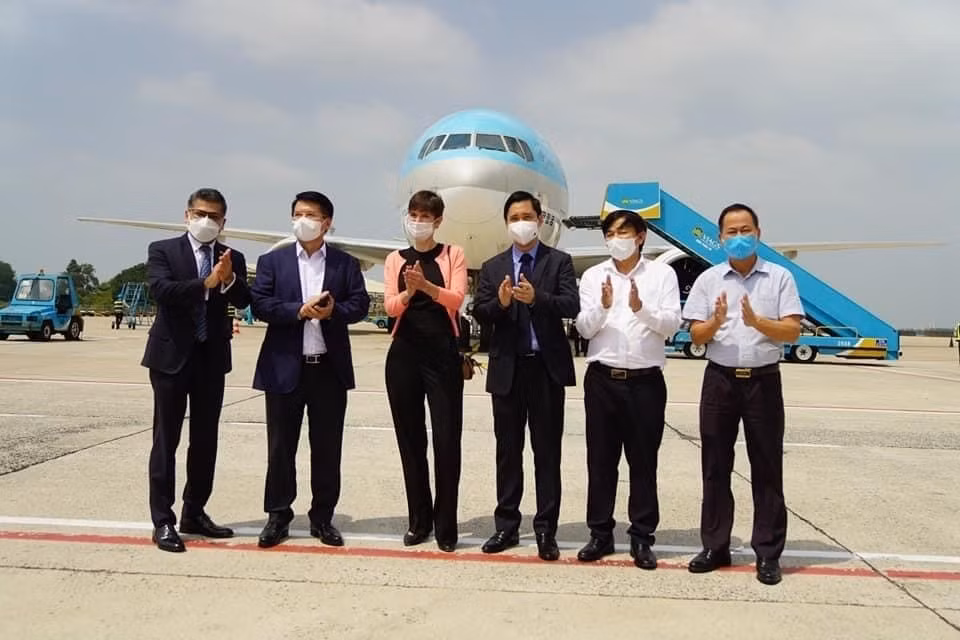  Tổng lãnh sự và Giám đốc Thương mại Vương quốc Anh tại Việt Nam Emily Hamblin và Thứ trưởng Bộ Y tế Trương Quốc Cường cùng đại diện công ty nhập khẩu tại sân bay đón lô vắcxin. (Ảnh: TTXVN phát)