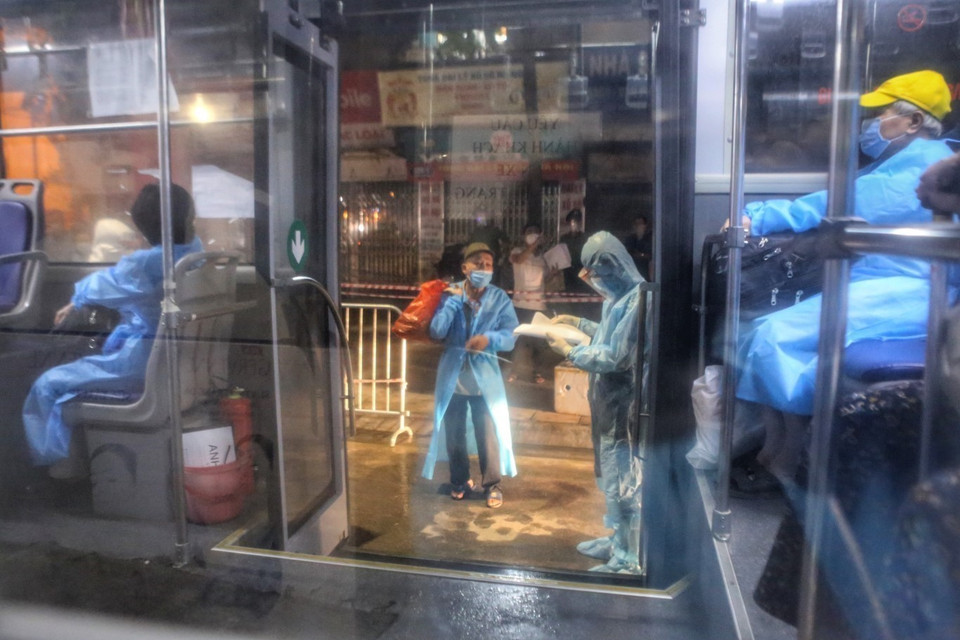 Nhân viên y tế kiểm tra danh sách người dân tại mỗi xe. (Ảnh: Tuấn Đức/TTXVN)