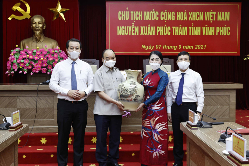 Chủ tịch nước Nguyễn Xuân Phúc tặng quà lưu niệm cho tỉnh Vĩnh Phúc. (Ảnh: Thống Nhất/TTXVN)