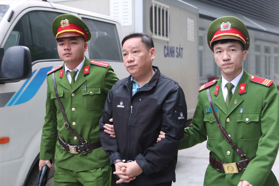 Cảnh sát dẫn giải bị cáo đến tòa xét xử. (Ảnh: Doãn Tấn/TTXVN)