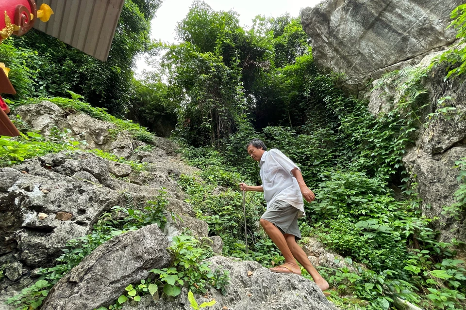 Hàng ngày, người quản lý khu di tích là ông Bùi Văn Nhàng mặc dù chân đau nhưng vẫn chống gậy lên chăm nom khu đền thượng. (Ảnh: Xuân Mai/Vietnam+)