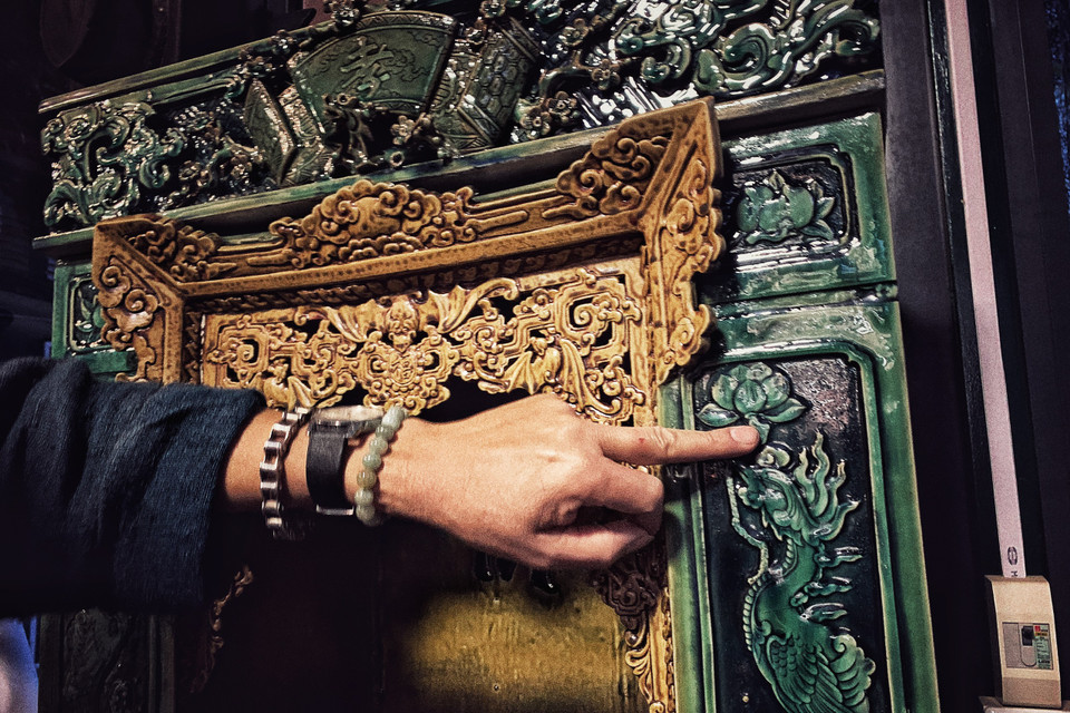 Với dòng men xanh ngọc được làm từ thủy tinh này, anh cũng phải tính toán kỹ để men chỉ chảy xuống tới chân khám thờ. Các họa tiết đều được đắp thủ công 'tay bo.' (Ảnh: Xuân Mai/Vietnam+)