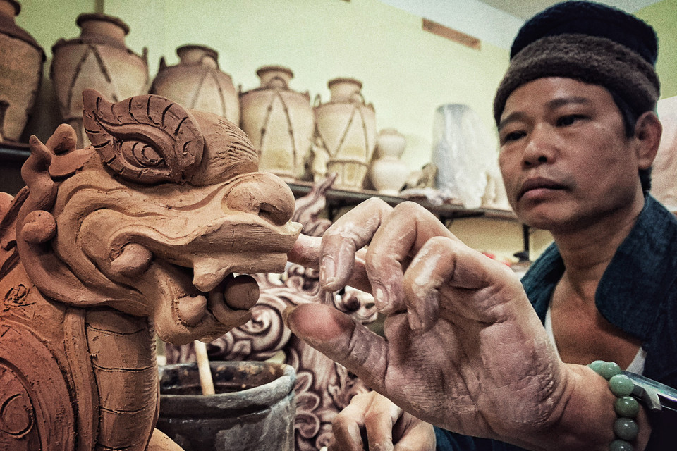 Gốm là niềm đam mê đến tận cùng của Trần Tước. Trong làm nghề, anh quan điểm rất rõ ràng, nếu là bảo tồn sẽ bảo tồn đến mức bảo thủ, còn nếu không phải bảo tồn thì tiếp biến để phát triển. (Ảnh: Xuân Mai/Vietnam+)