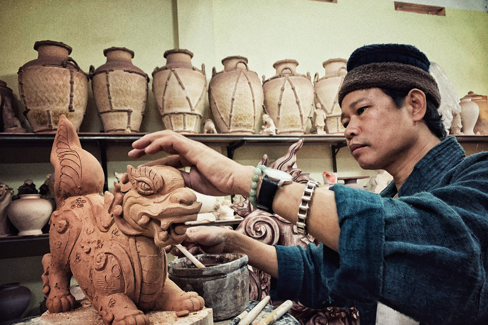 Anh đang hoàn thiện cặp Sấu thời Lý. (Ảnh: Xuân Mai/Vietnam+)