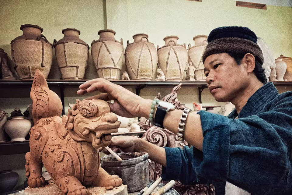 Anh đang hoàn thiện cặp Sấu thời Lý. (Ảnh: Xuân Mai/Vietnam+)