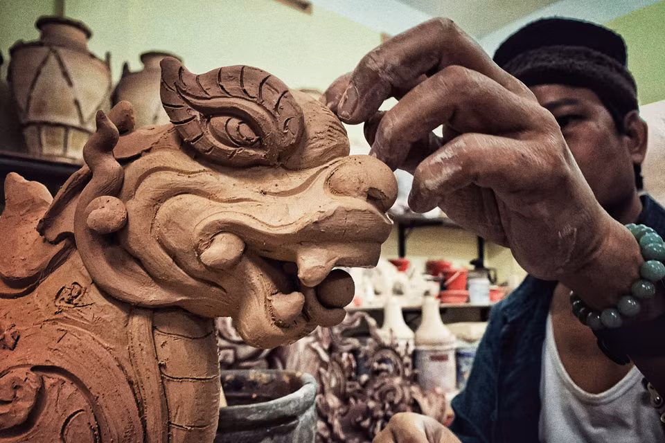 'Kỹ thuật làm gốm của tôi là hoàn toàn dựa trên kỹ thuật của gốm Bát Tràng cổ nhưng trong quá trình làm việc, có những anh em sẽ phục chế còn tư tưởng của tôi là người bảo tồn nhưng phải phát triển, nên mặc dù những sản phẩm của tôi làm nhìn có vẻ cổ điển nhưng đều là sáng mới của tôi, từ kiểu dáng cho đến chất liệu, màu men và nội dung, nhưng vẫn dựa trên cơ sở xương da truyền thống của Bát Tràng,' nghệ nhân Trần Tước chia sẻ. (Ảnh: Xuân Mai/Vietnam+)