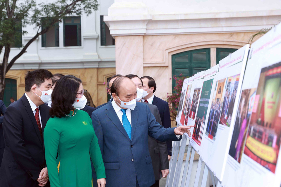 Chủ tịch nước Nguyễn Xuân Phúc xem trưng bày ảnh do Thông tấn xã Việt Nam và Học viện Nông nghiệp Việt Nam phối hợp tổ chức. (Ảnh: Thống Nhất/TTXVN)