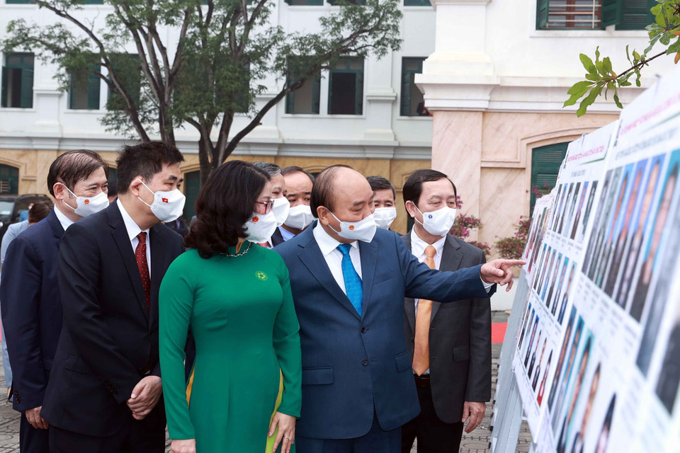 Chủ tịch nước Nguyễn Xuân Phúc xem trưng bày ảnh do Thông tấn xã Việt Nam và Học viện Nông nghiệp Việt Nam phối hợp tổ chức. (Ảnh: Thống Nhất/TTXVN)