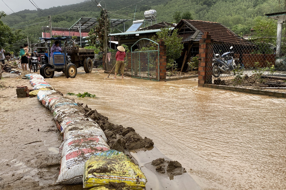 Người dân dựng các đê tạm để ngăn bùn đất trôi vào nhà. (Ảnh: Tường Quân/TTXVN)