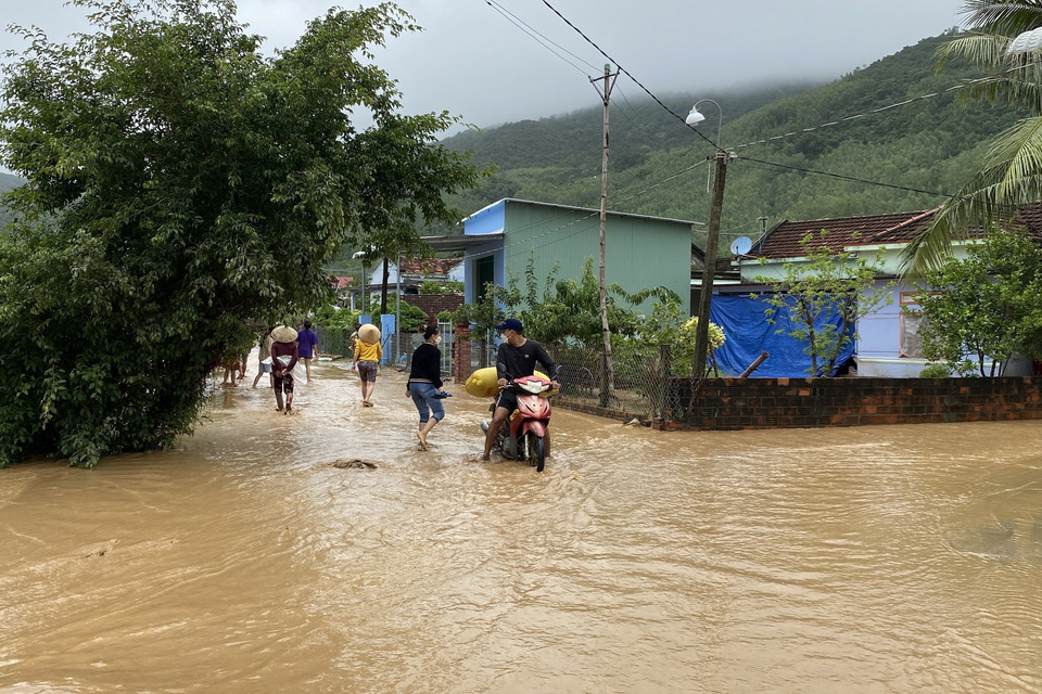 Tuyến đường bêtông chính của thôn Chánh Thắng ngập tràn bùn đất từ trong núi chảy ra. (Ảnh: Tường Quân/TTXVN)