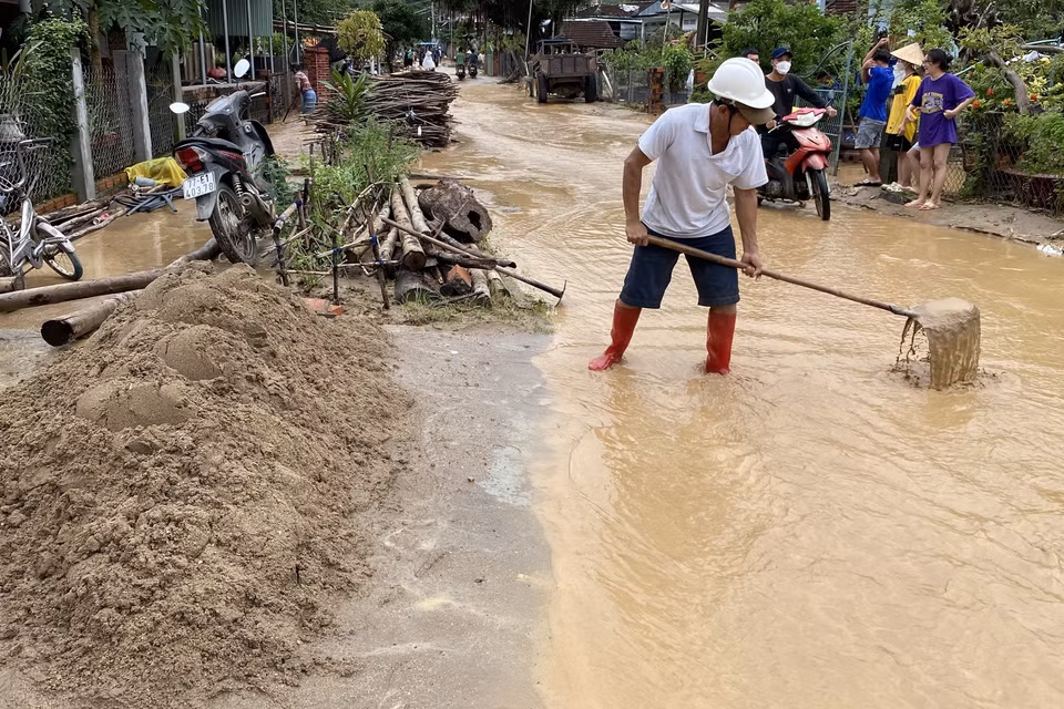 Người dân nạo vét bùn đất trên đường bêtông. (Ảnh: Tường Quân/TTXVN)
