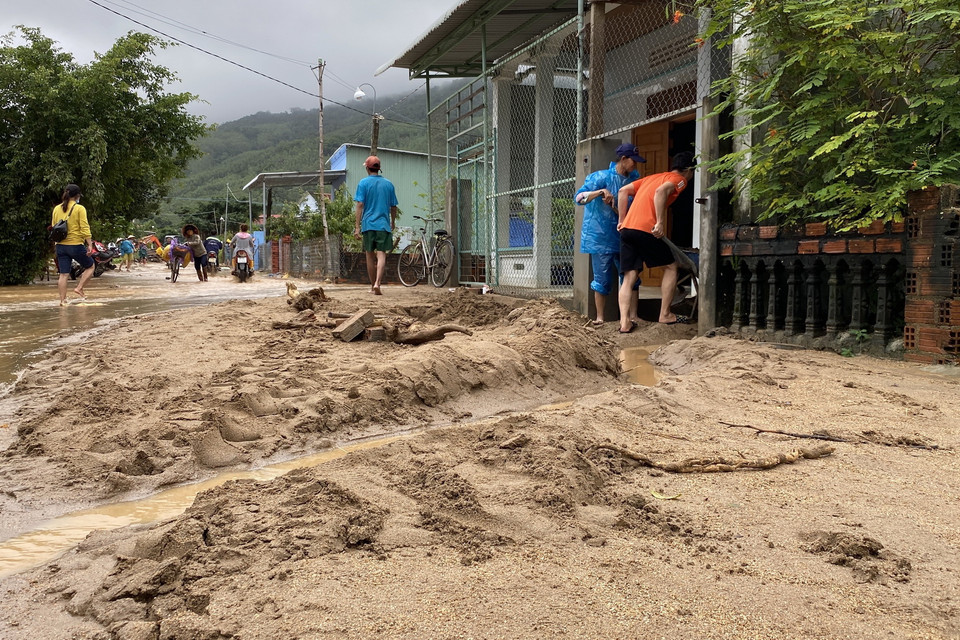 Bùn đất dày trên 30cm tràn xuống đường bê tông thôn Chánh Thắng. (Ảnh: Tường Quân/TTXVN)