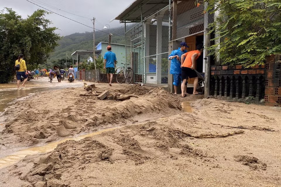 Bùn đất dày trên 30cm tràn xuống đường bê tông thôn Chánh Thắng. (Ảnh: Tường Quân/TTXVN)