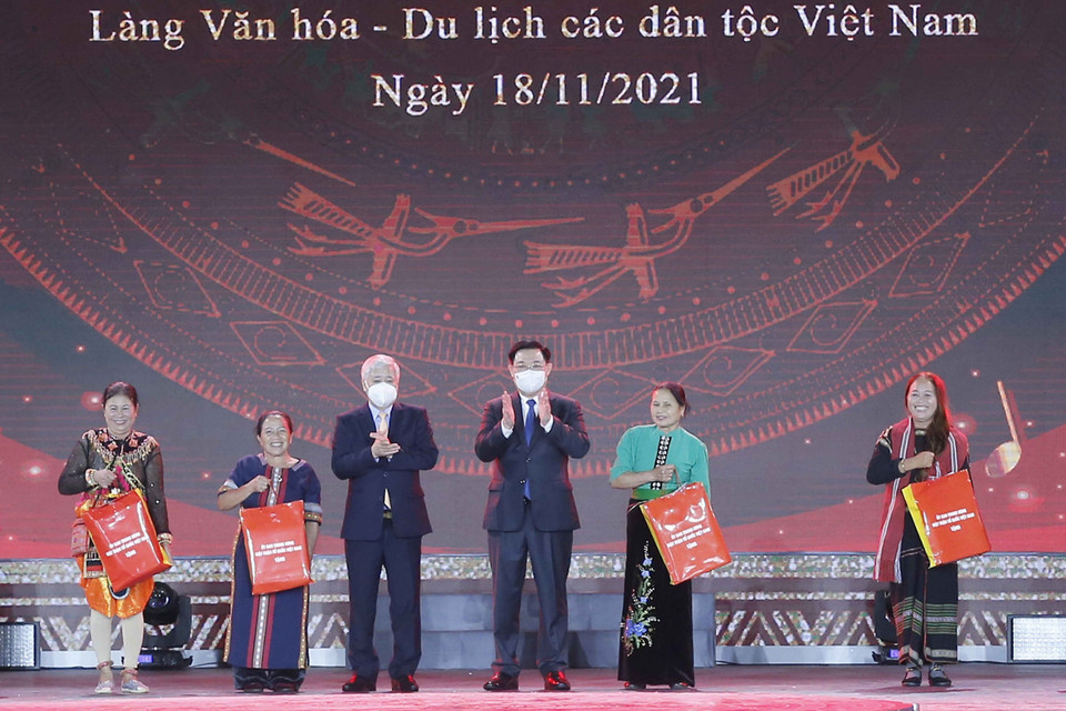 Chủ tịch Quốc hội Vương Đình Huệ và Chủ tịch Ủy ban Trung ương Mặt trận Tổ quốc Việt Nam Đỗ Văn Chiến trao quà cho các đại biểu dân tộc tại Làng Văn hóa. (Ảnh: Doãn Tấn/TTXVN)