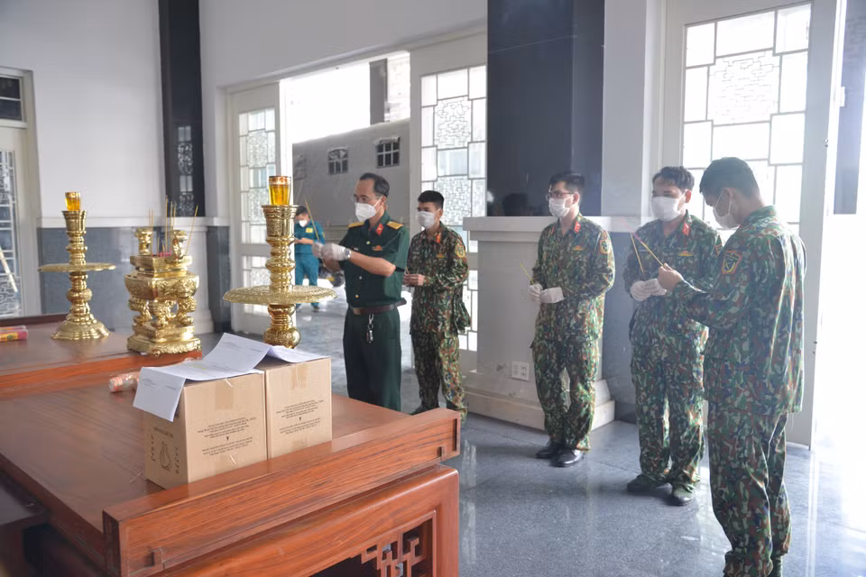 Các cán bộ, chiến sỹ của Bộ Tư lệnh TP Hồ Chí Minh thắp hương trước các anh linh người tử vong vì COVID-19 trước khi giao về nhà cho thân nhân. (Ảnh: Mạnh Linh/TTXVN)