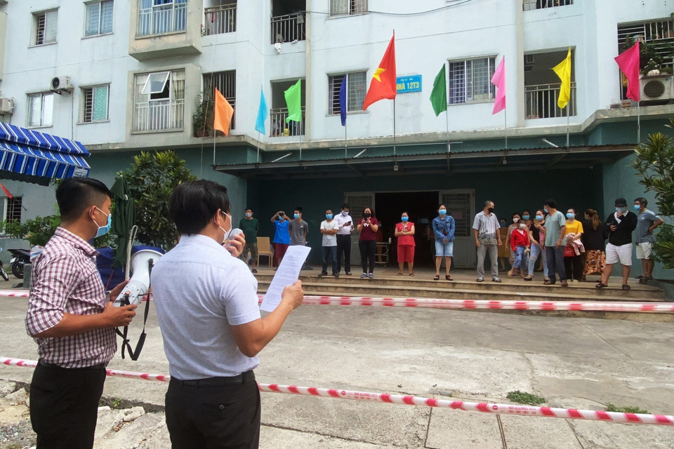 Lãnh đạo địa phương công bố gỡ phong tỏa chung cư 12T3. (Ảnh: Văn Dũng/TTXVN)