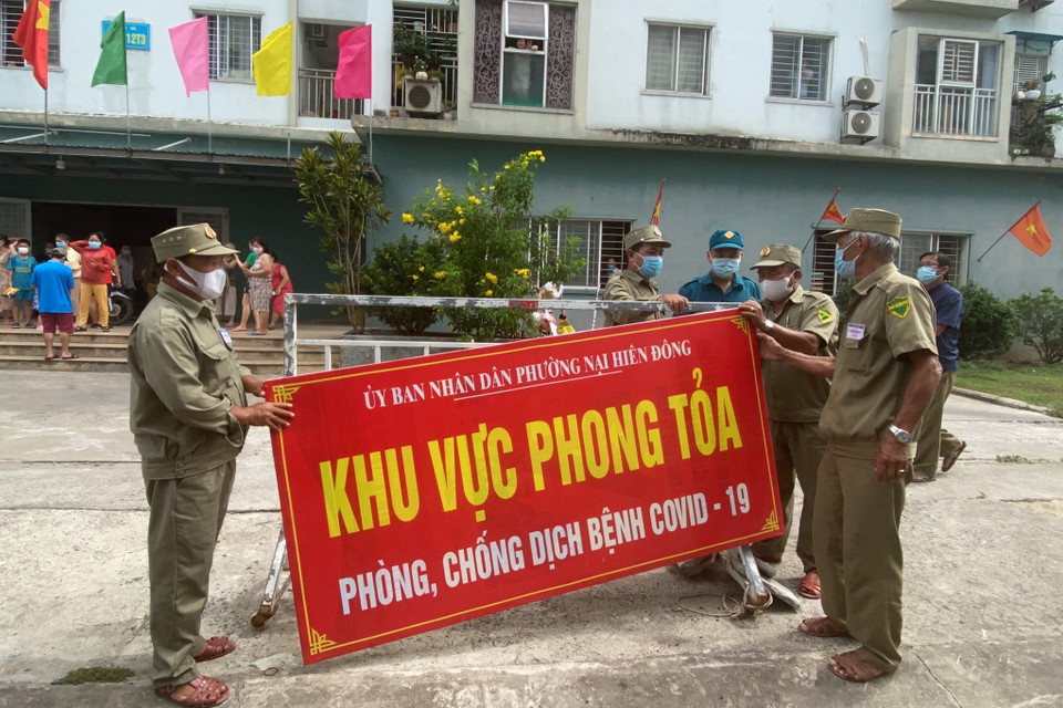 Lực lượng chức năng gỡ phong tỏa chung cư 12T3. (Ảnh: Văn Dũng/TTXVN)