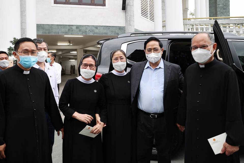 Thủ tướng Phạm Minh Chính thăm hỏi các giáo dân giáo xứ Long Hương nhân dịp Lễ Giáng sinh 2021. (Ảnh: Dương Giang/TTXVN)