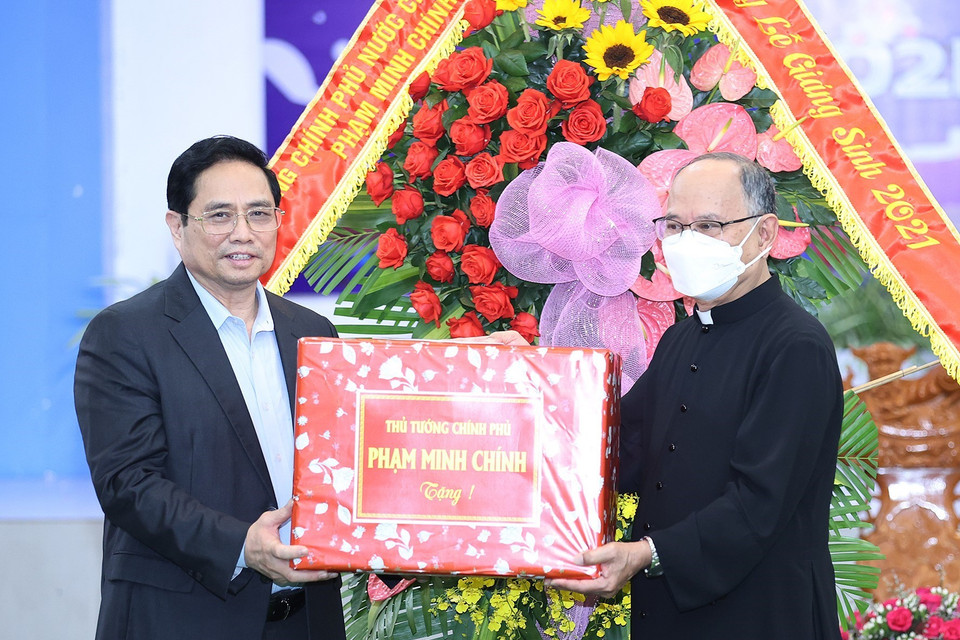 Thủ tướng Phạm Minh Chính tặng quà chúc mừng giáng sinh giáo dân giáo xứ Long Hương. (Ảnh: Dương Giang/TTXVN)