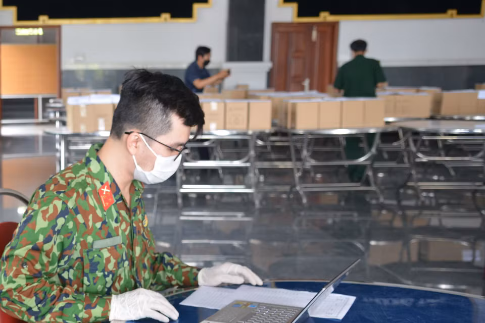 Các cán bộ, chiến sỹ của Bộ Tư lệnh Thành phố Hồ Chí Minh kiểm tra tro cốt người tử vong vì COVID-19 trước khi giao về nhà cho thân nhân. (Ảnh: Mạnh Linh/TTXVN)