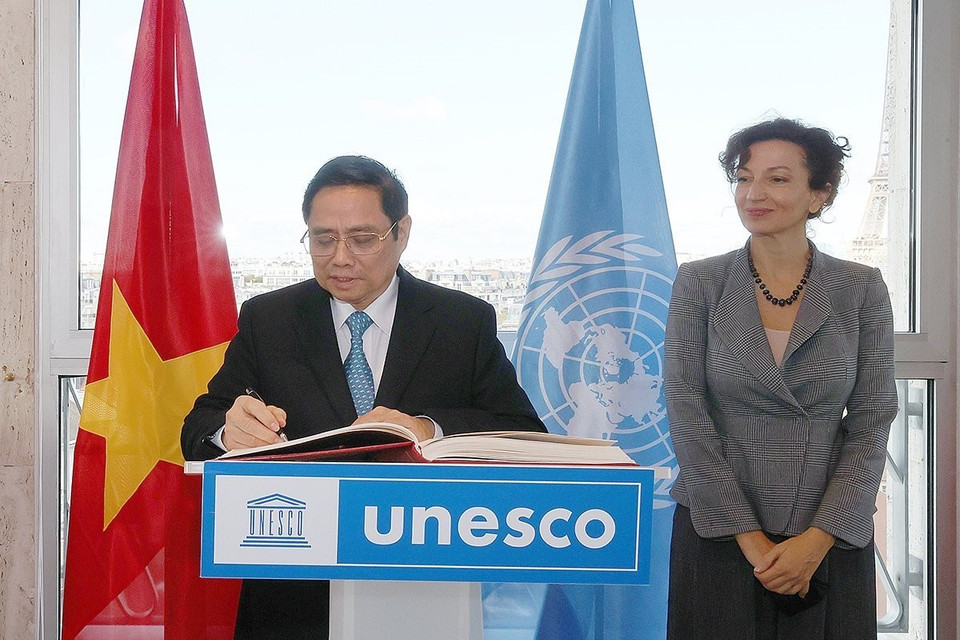 Thủ tướng Phạm Minh Chính viết sổ lưu bút tại Trụ sở UNESCO. (Ảnh: Dương Giang/TTXVN)