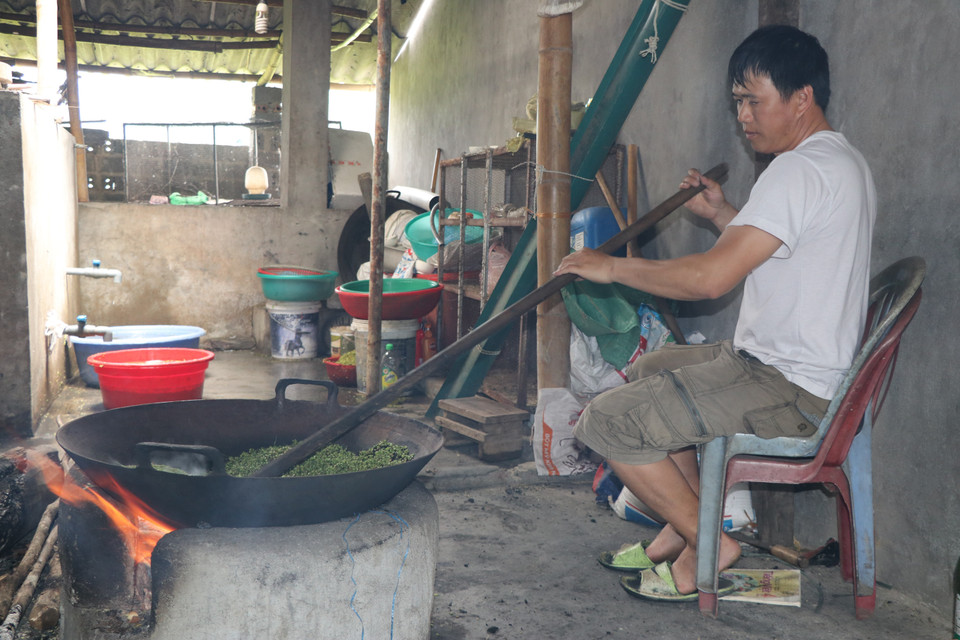 Sau khi được tuốt, loại bỏ hạt lép, lúa được đem rang trong chảo lớn. Lửa phải được duy trì đều trong khoảng 30 phút đến khi nứt hạt và dậy mùi thơm. (Ảnh: Tiến Khánh/TTXVN)